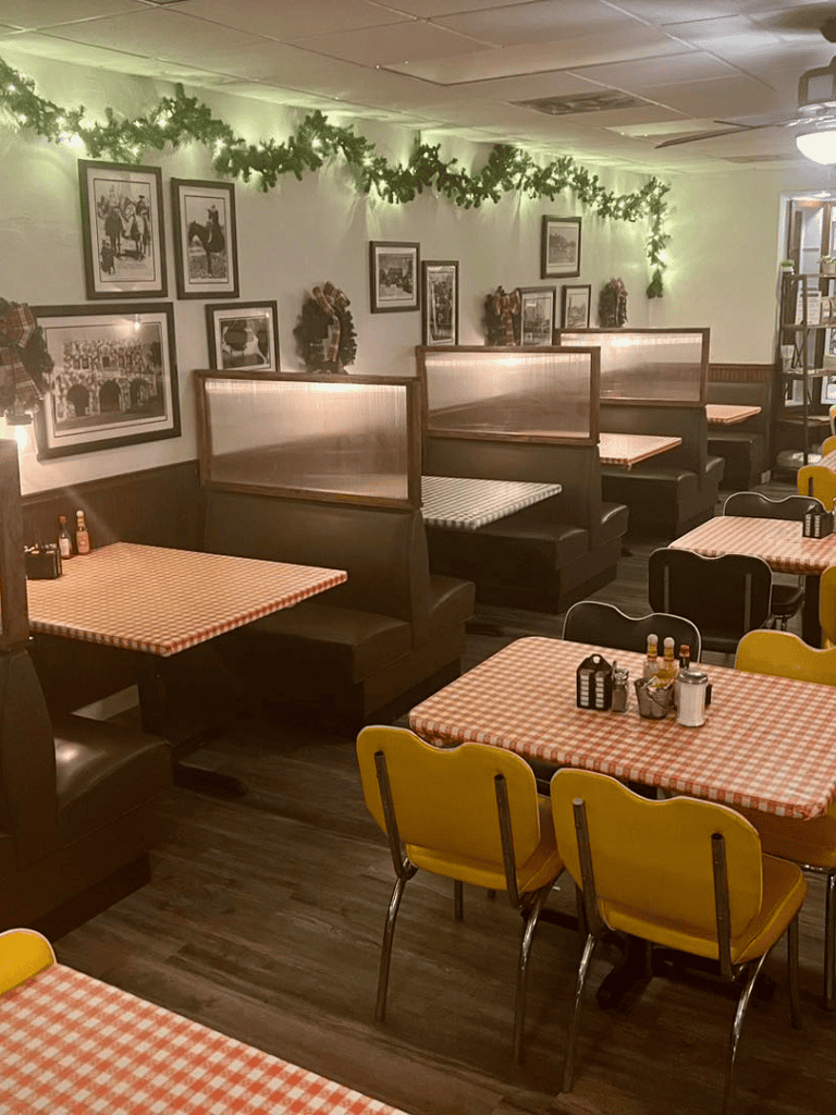 Cozy restaurant with checkered tablecloths, vintage decor, and festive greenery for holiday dining.