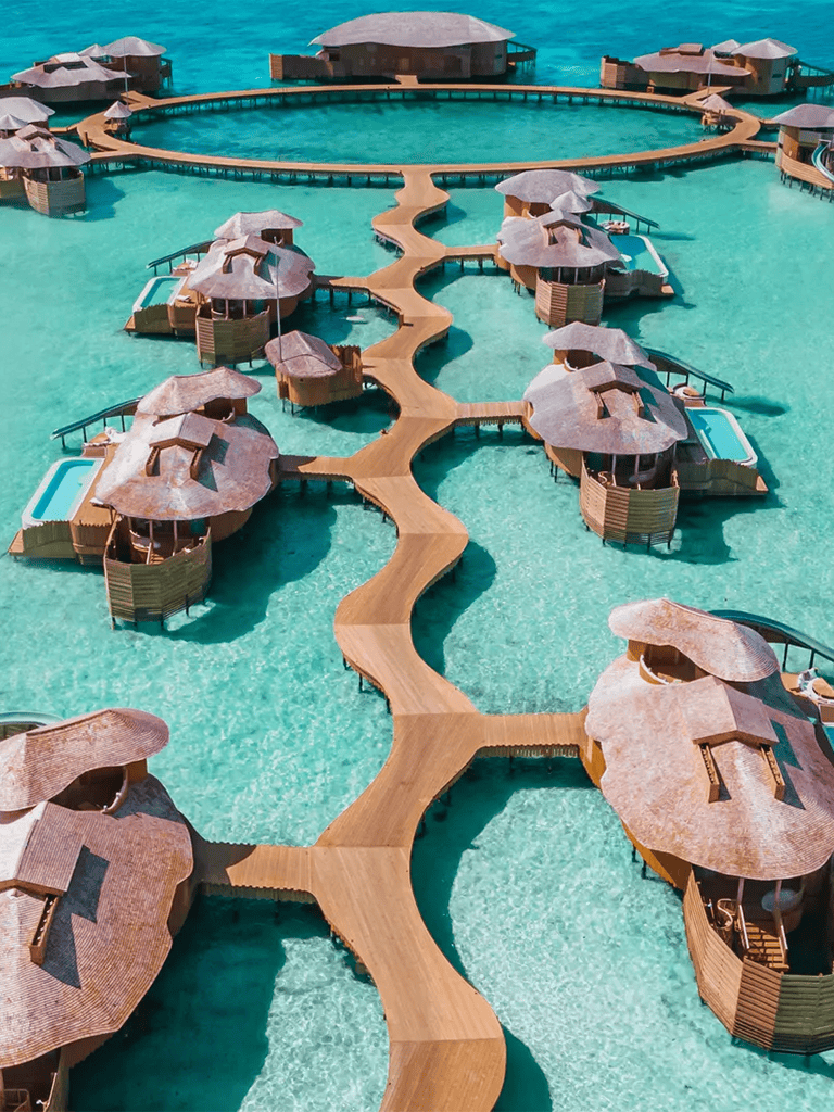 Overwater bungalows with connecting wooden walkways at a tropical resort.