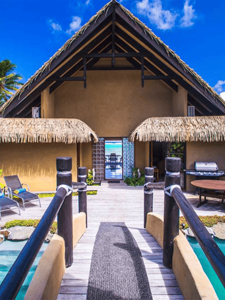 Stunning tropical beachfront villa with thatched roof, pool, and ocean view for a perfect getaway.