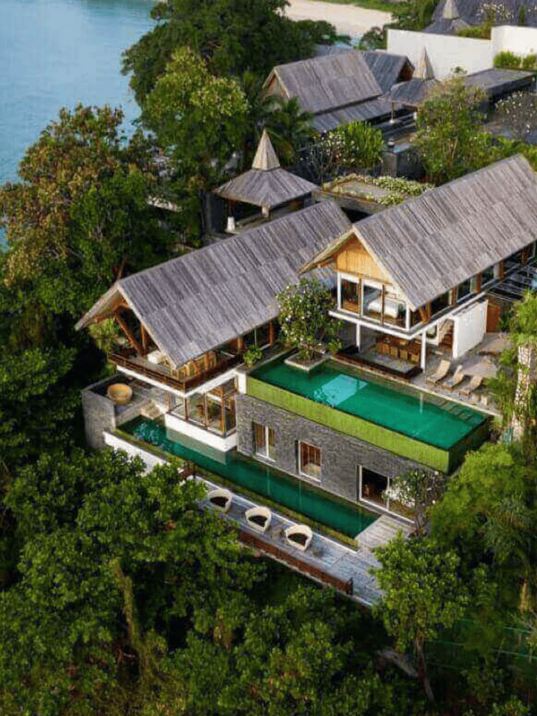 Luxurious tropical villa with private pool and lush greenery, beachfront view, and modern architecture.