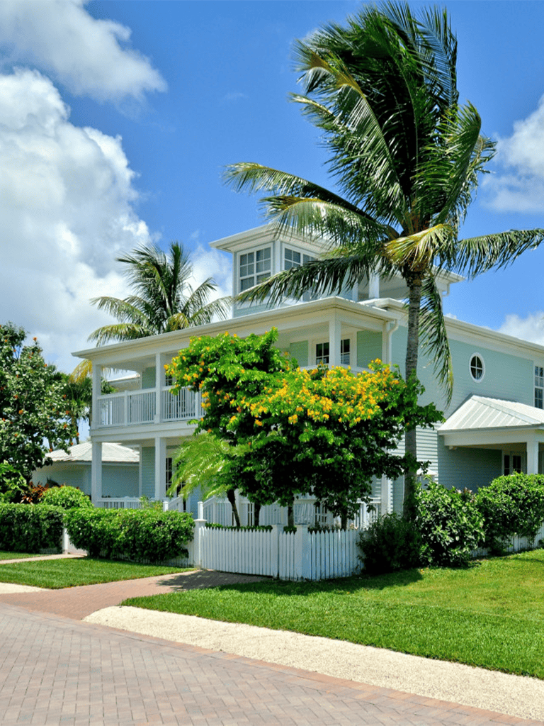 Luxury coastal vacation home in sunny Florida with palm trees and tropical landscaping.
