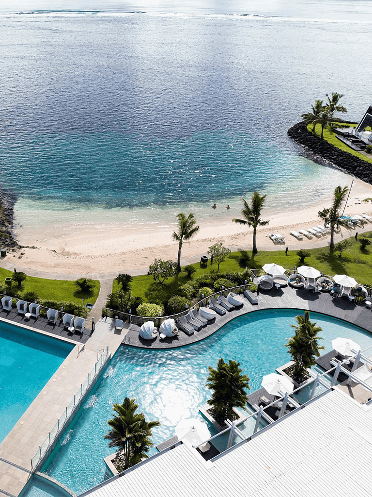 Relaxing beach resort with swimming pool and ocean view, perfect for vacations and tropical getaways.