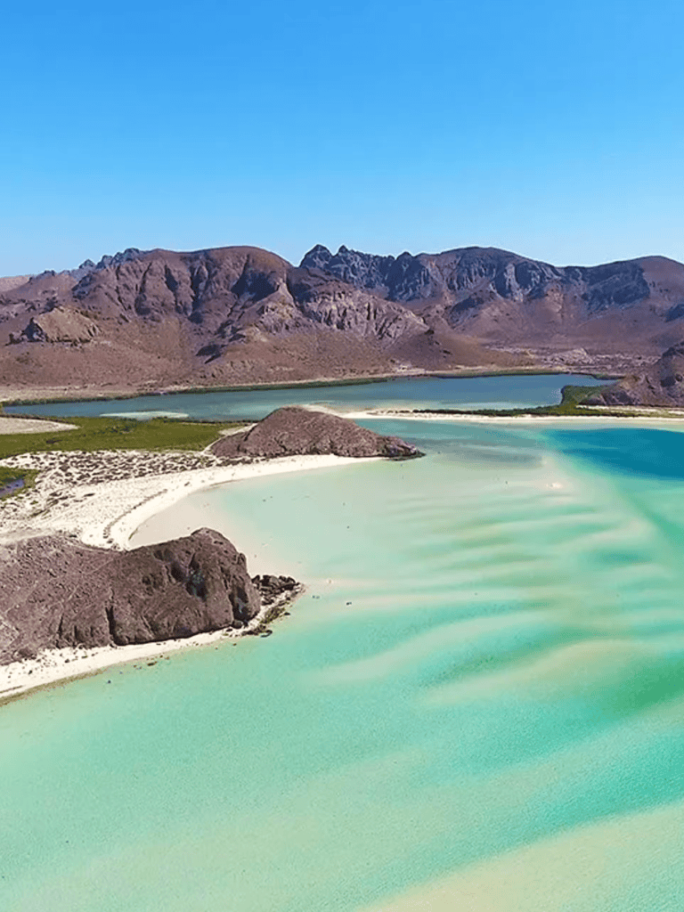 Bright turquoise lake surrounded by mountains and desert landscape, scenic outdoor location.