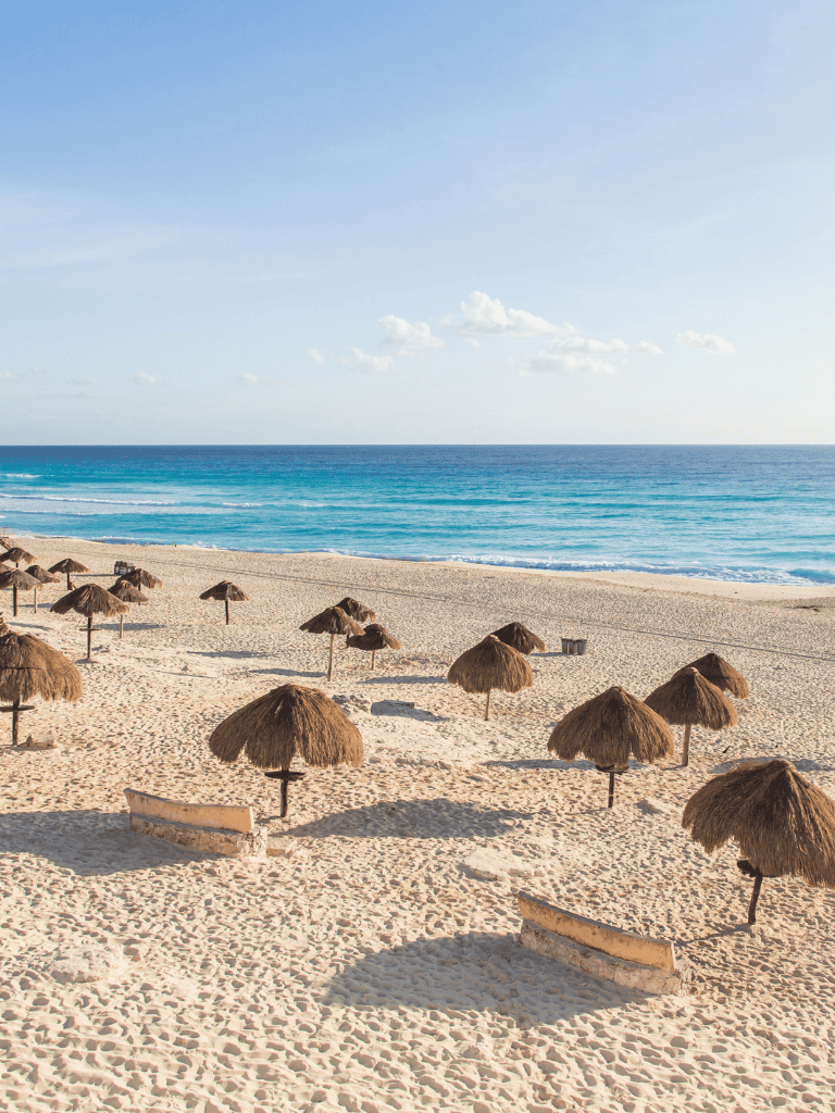 Secluded beach with straw umbrellas and turquoise ocean, perfect for relaxation and seaside adventures.