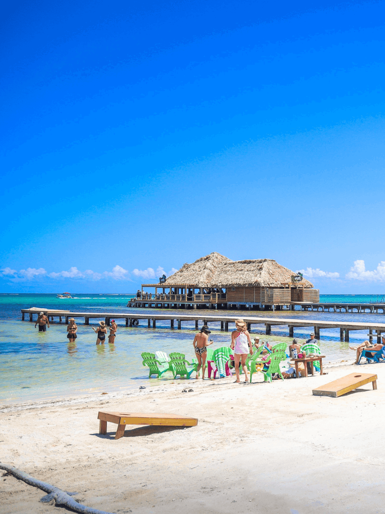 Relaxing beach with turquoise water and thatched-roof overwater restaurant at Quest For Directions.