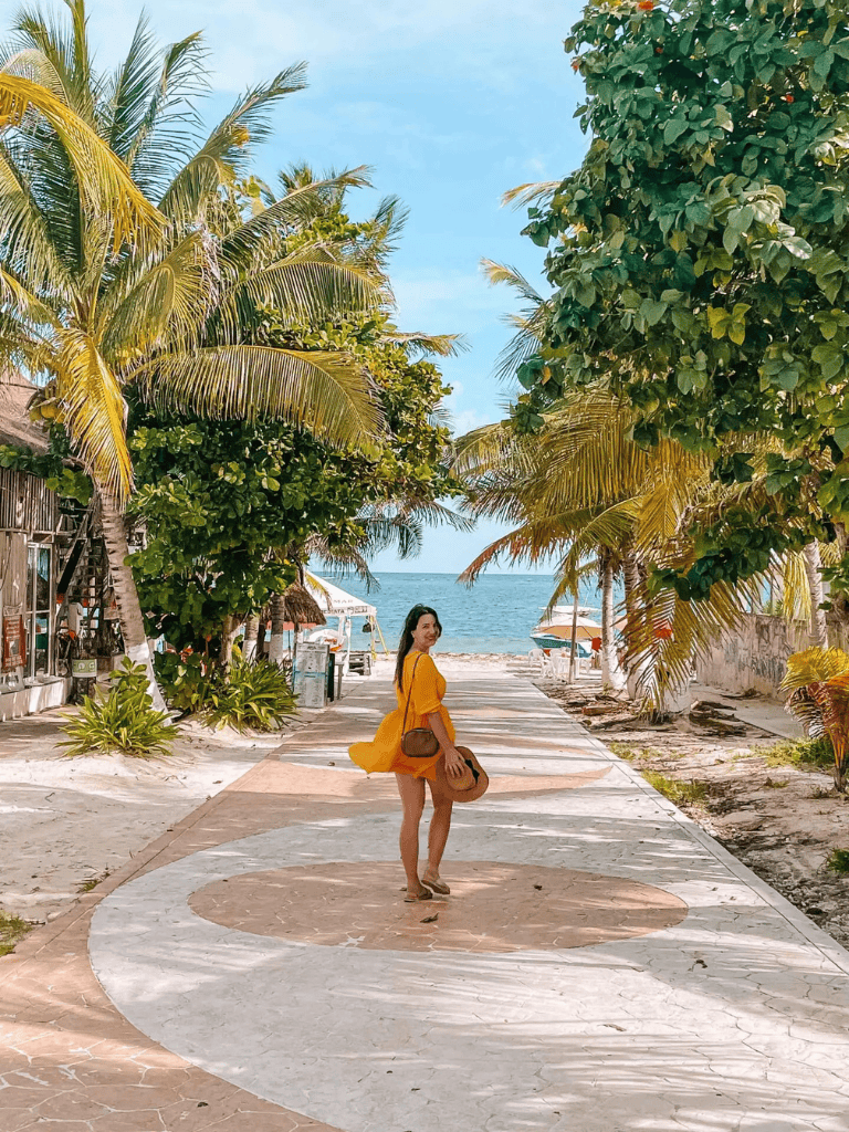 Relaxing beachside pathway in Tulum with palm trees and ocean view, perfect for vacation travel.