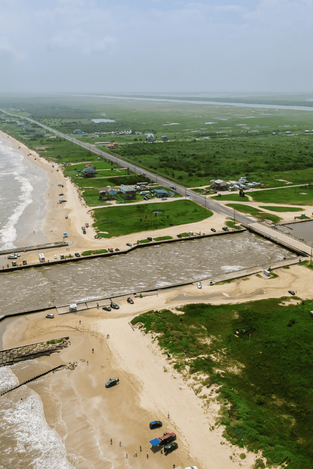 Seaside coastal area with beach, ocean waves, and beachfront facilities, ideal for beach vacation and water activities.