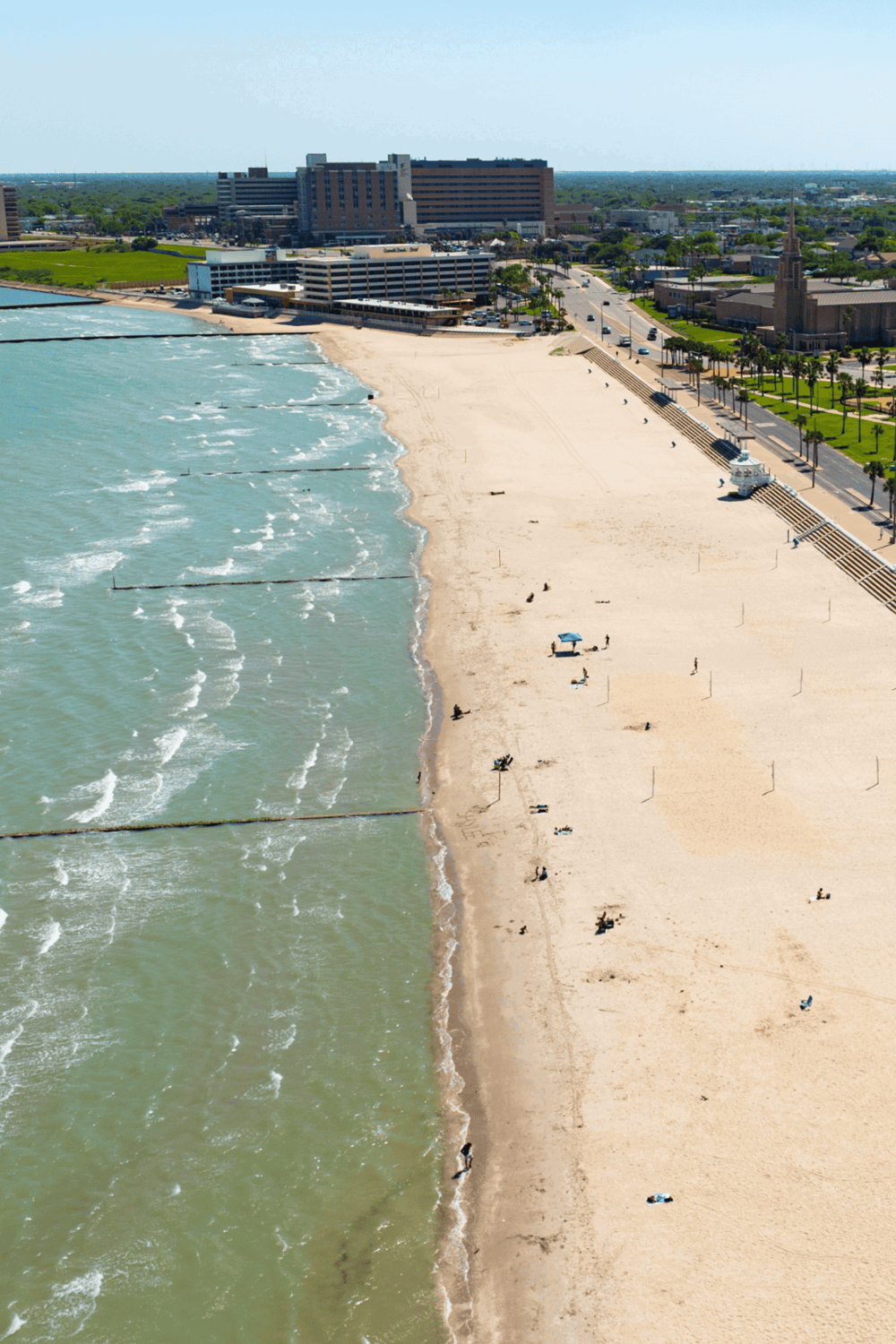 Beach shoreline with nearby cityscape and ocean waves, coastal scenery in QuestForDirections.