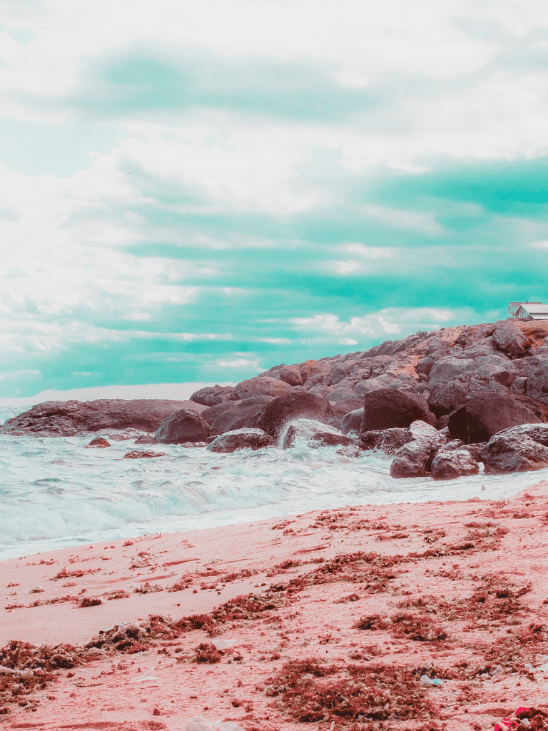Gentle ocean waves crashing on rocky beach with cloudy sky, scenic coastal landscape at QuestForDirections.