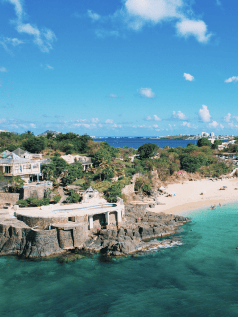 Breathtaking coastal scenery with luxury homes, sandy beach, and turquoise waters at QuestForDirections.