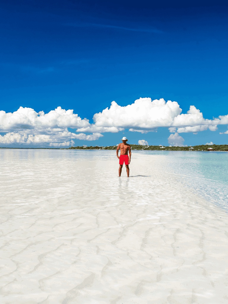 Secluded beach with crystal-clear water and blue sky, perfect for relaxing and vacation plans.