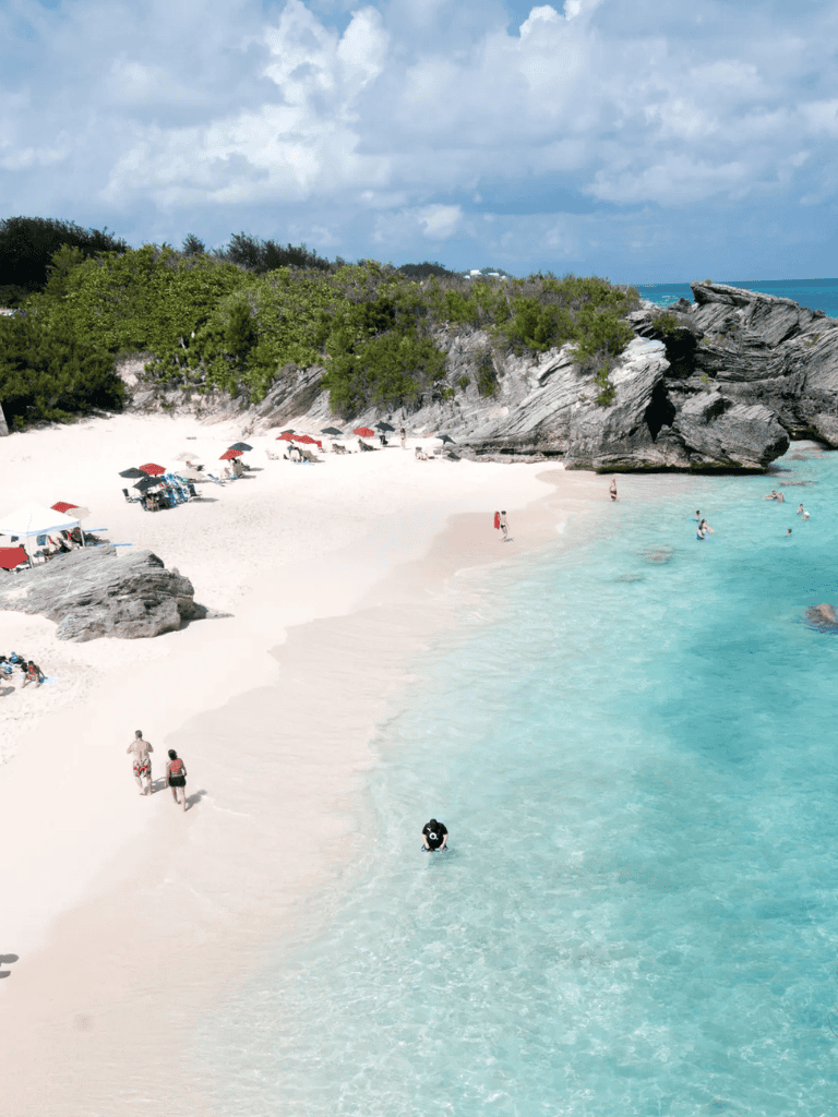 1. Beautiful tropical beach with white sand, turquoise waters, and rocky cliffs.