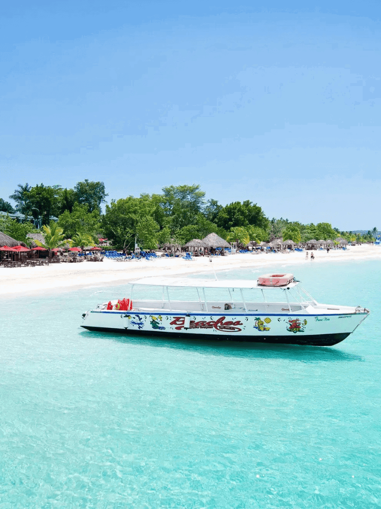 Boat on clear turquoise water at a tropical beach resort.