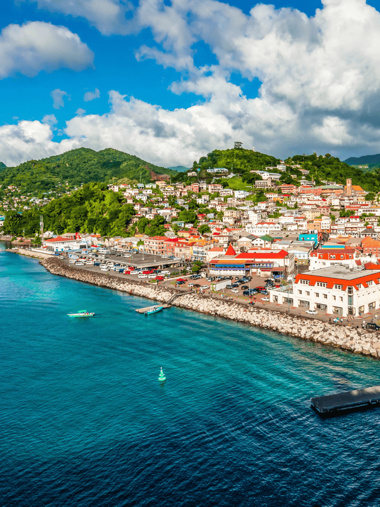 Vibrant seaside town with colorful buildings, lush green hills, and clear blue waters, perfect for travel and exploration.