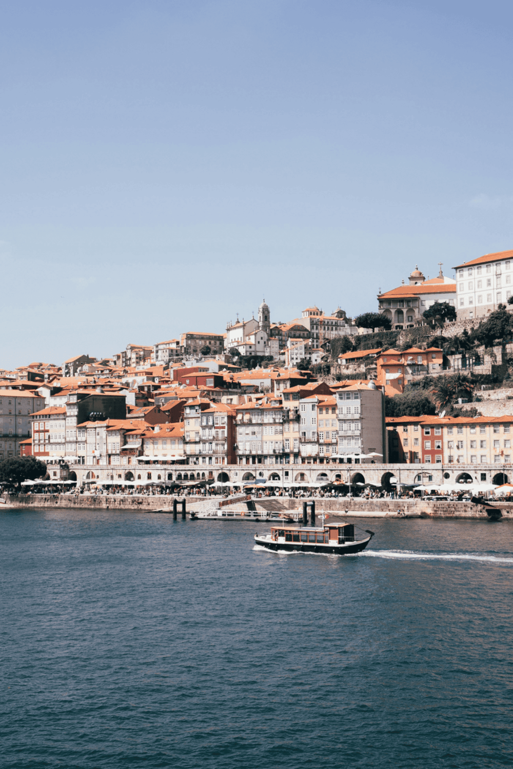 Charming coastal cityscape with colorful buildings and a boat on the water, ideal for travel and navigation.
