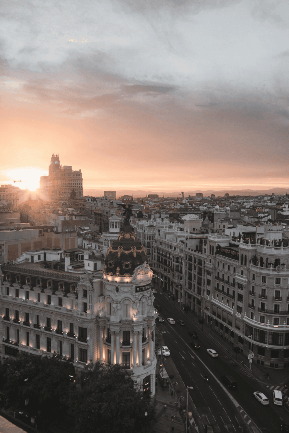 Sunset over Madrid with Metropolis Building and city streets, a beautiful urban landscape.