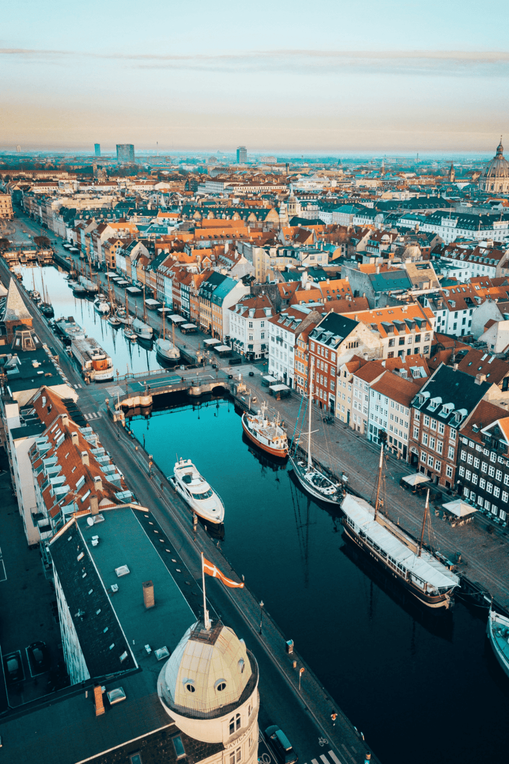 Historic European harbor with colorful buildings and sailboats in Copenhagen, Denmark.