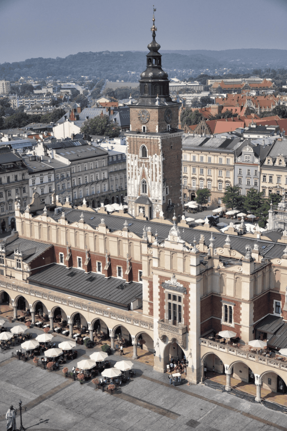 Ancient clock tower and historic city square in Prague, Czech Republic, featuring architecture and outdoor cafes.