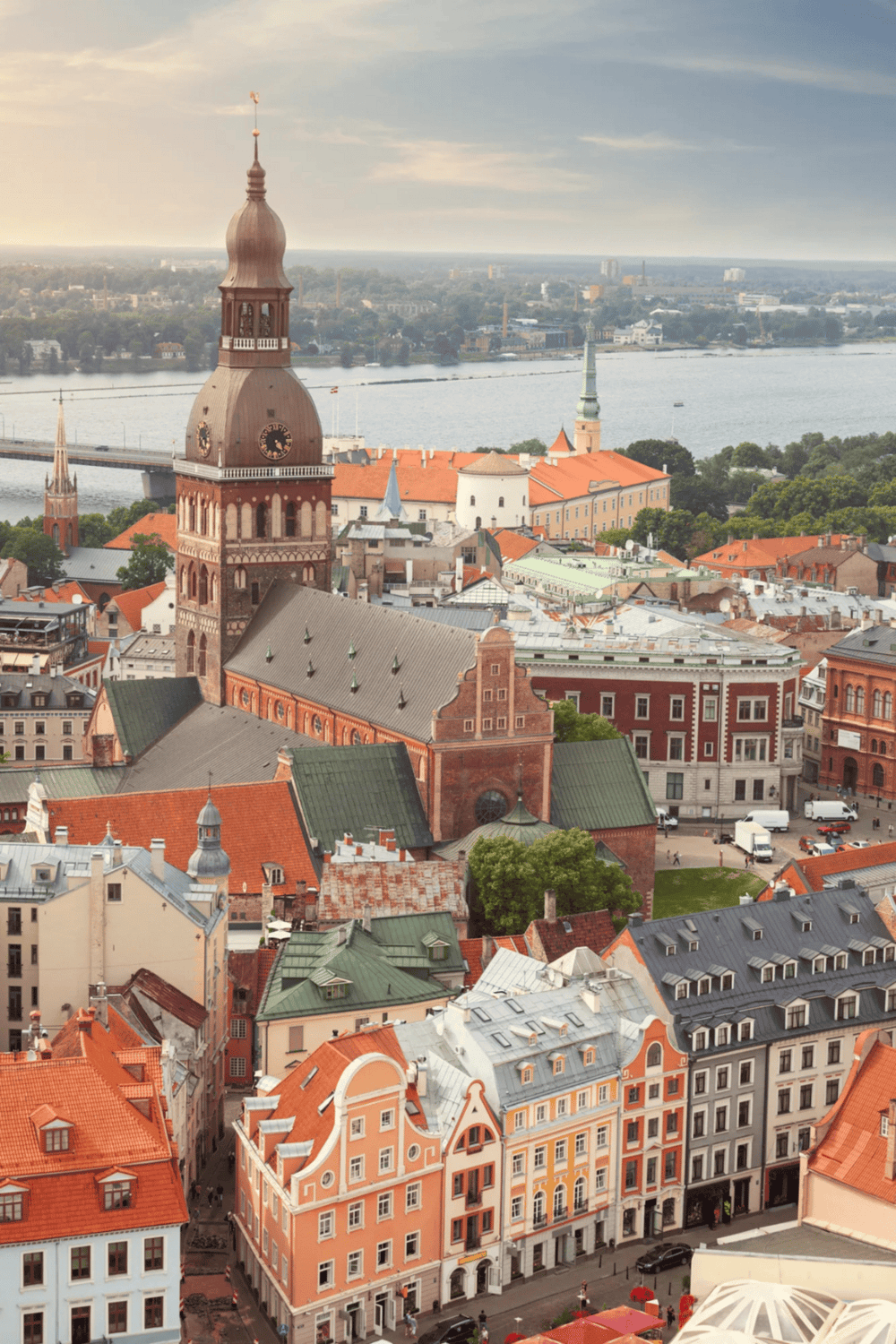 Colorful historic cityscape with red brick churches, vibrant buildings, and scenic river views in Riga, Latvia.