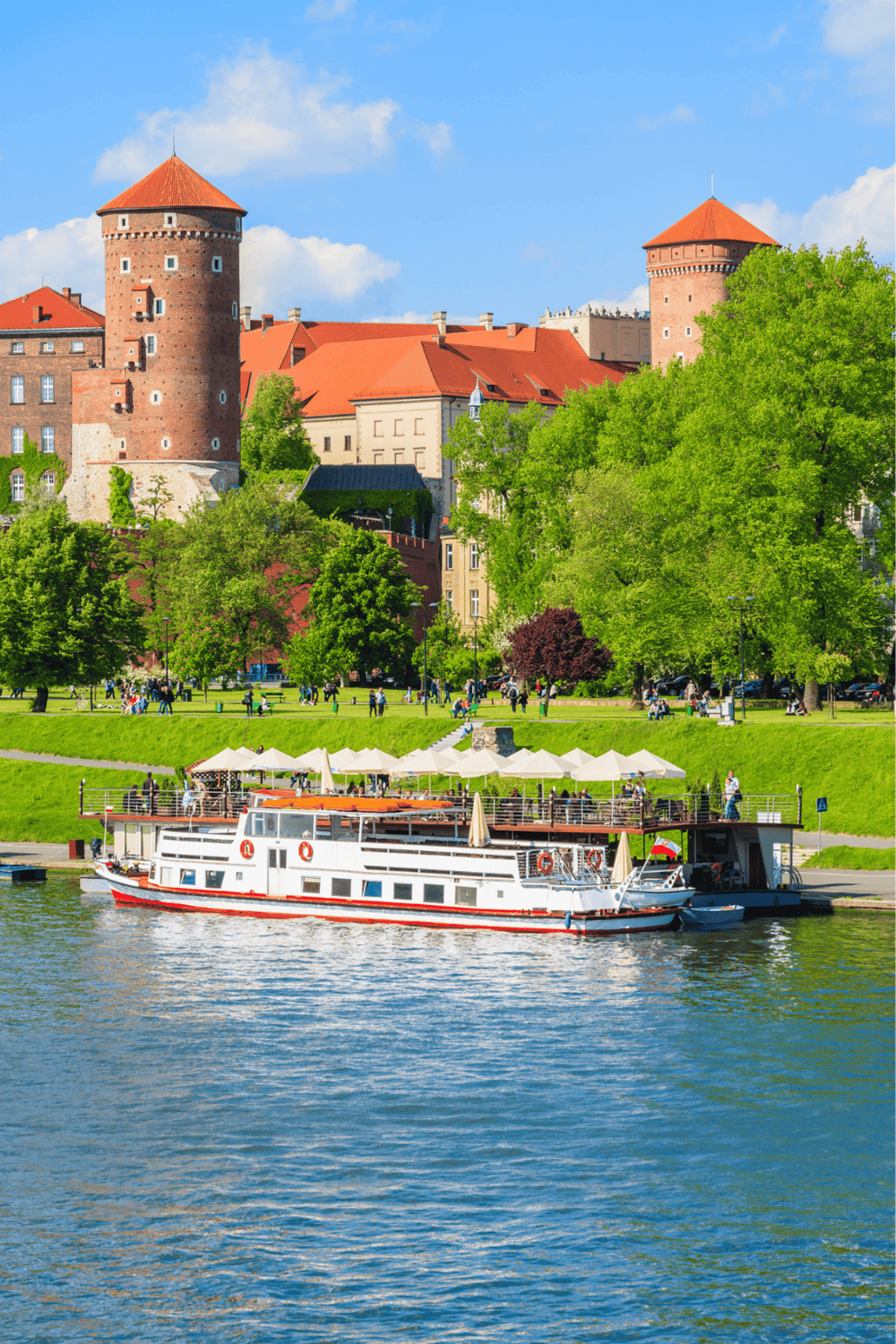 1. Historic castle towers on a scenic riverfront in Poland, perfect for travel guides.