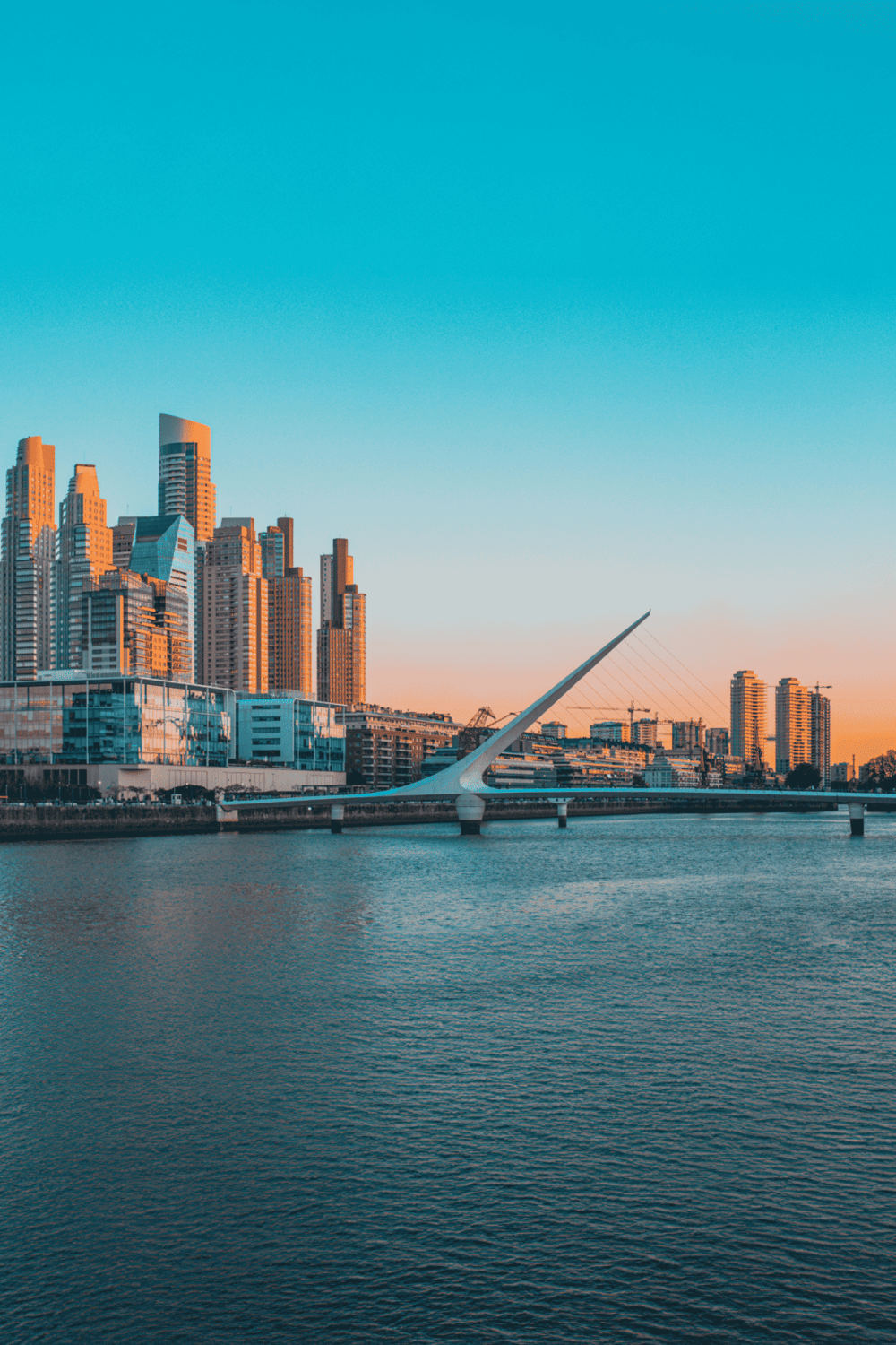 Modern downtown cityscape with unique bridge and skyscrapers at sunset, digital illustration, urban development, iconic landmarks.