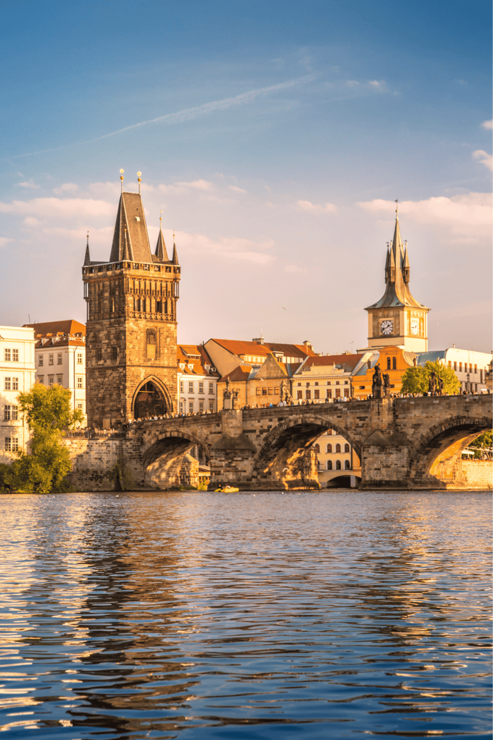 Ancient Charles Bridge and tower in Prague, Czech Republic at sunset.