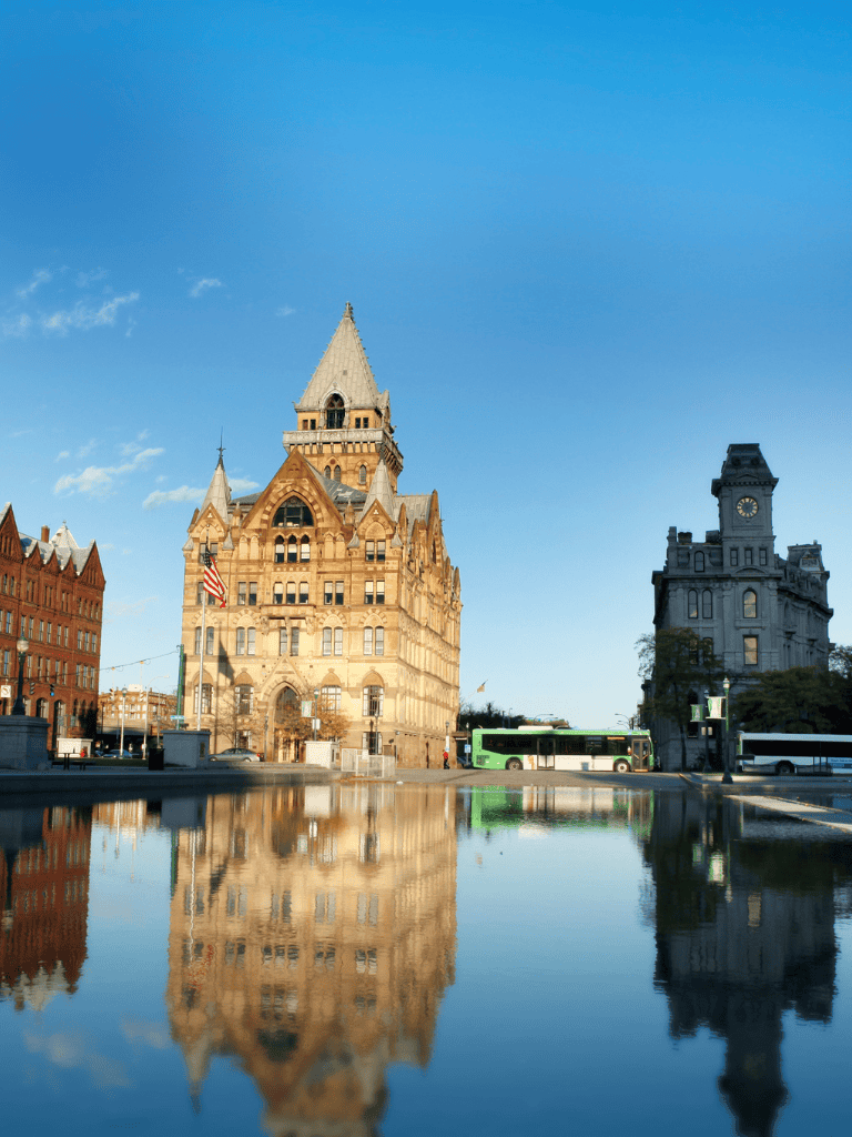Historic courthouse building in downtown city with reflection in water, near Quest for Directions.
