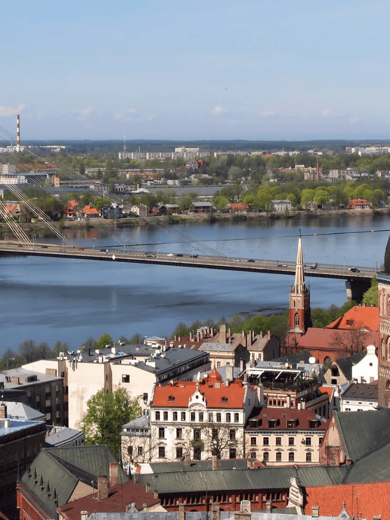 Vibrant cityscape with historic buildings, river view, and bridge in the background, perfect for exploring urban destinations.
