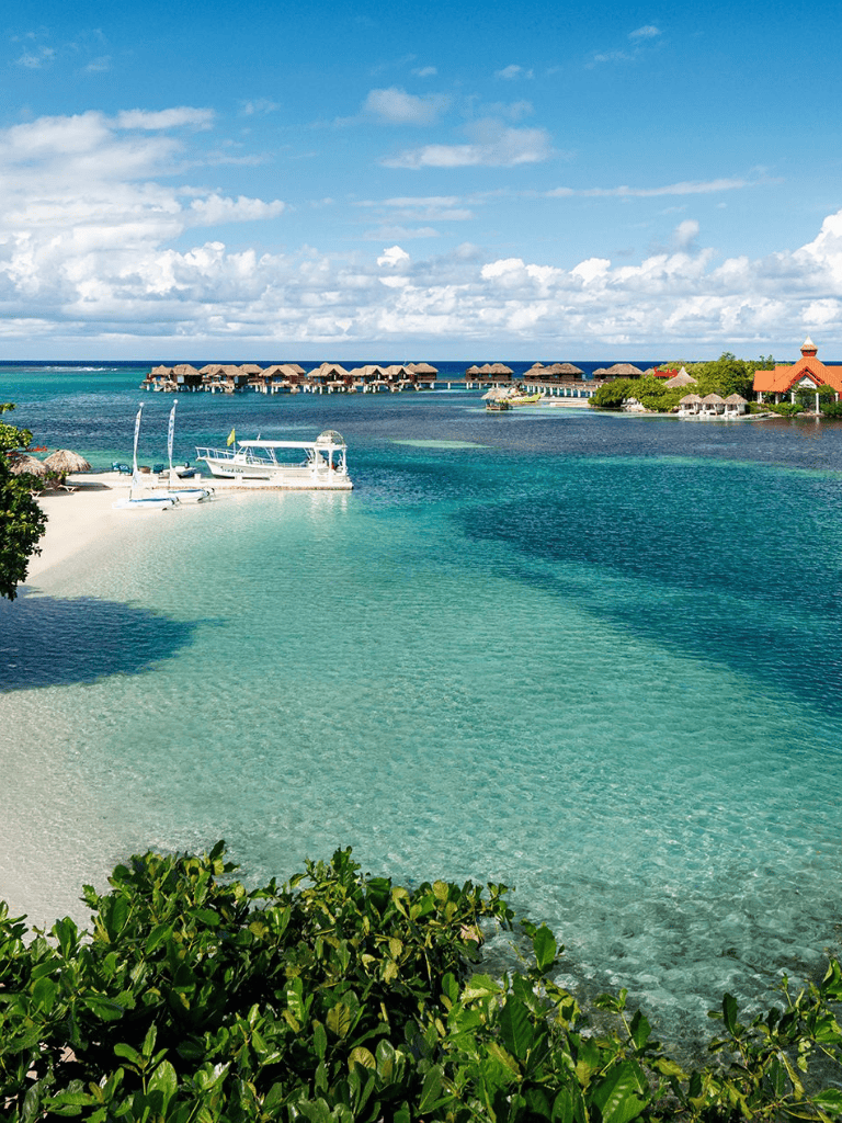 Pristine Caribbean overwater bungalows at tropical island resort with clear turquoise water.