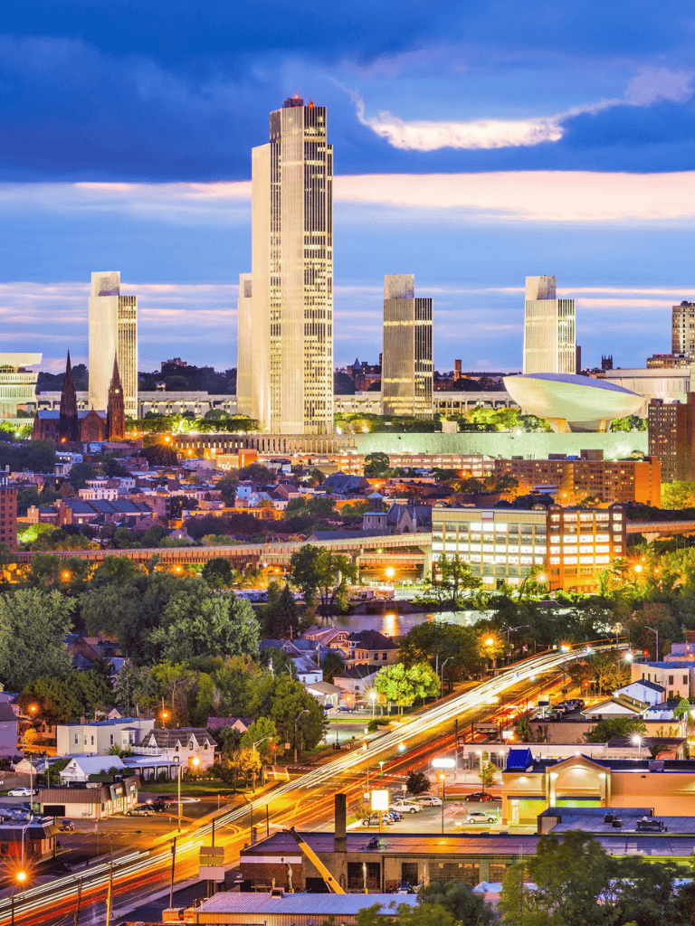 High-rise skyline of Nashville, Tennessee at dusk with city lights and vibrant sky.