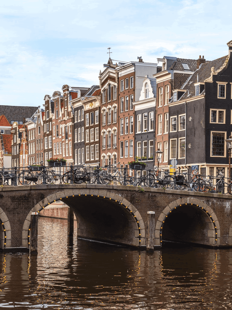 Charming Dutch canal with historic row houses and bicycles in Amsterdam, Netherlands.