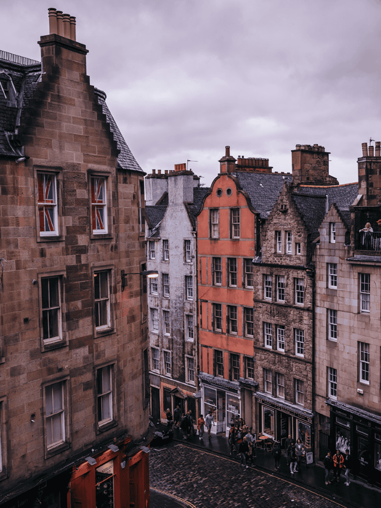 Vintage European city street with colorful historic buildings and a wet cobblestone road.