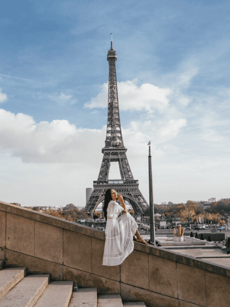 Eiffel Tower in Paris with woman in white dress posing, travel, landmarks, sightseeing, France.