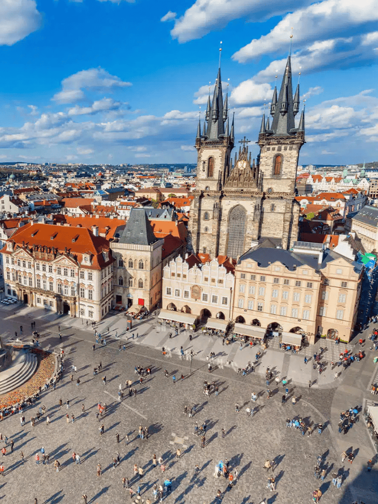 Historic Prague Old Town Square with Týn Church and horse-drawn carriages, popular travel destination in Czech Republic.