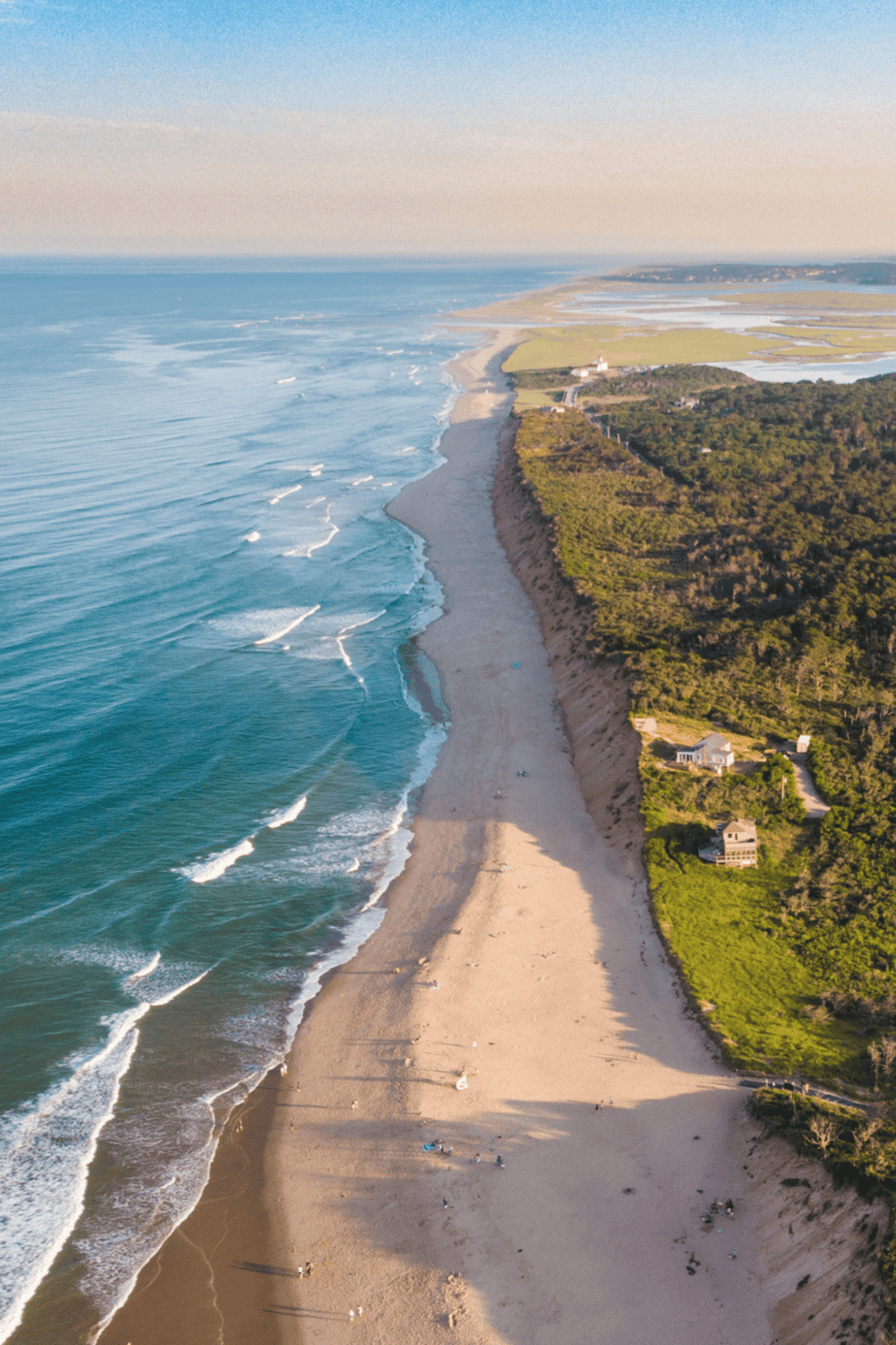 Gorgeous aerial view of a coastal beach with cliffs and ocean waves, perfect for travel and adventure.