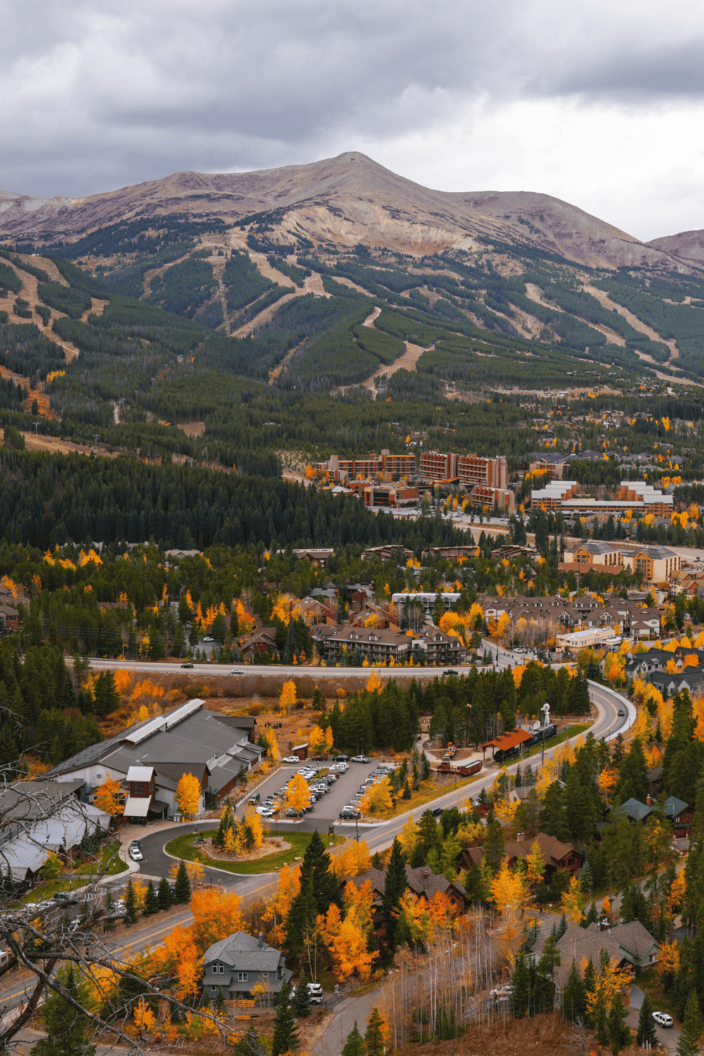 Scenic mountain town with fall foliage, lush forests, and winding roads, ideal for travel and outdoor adventures.