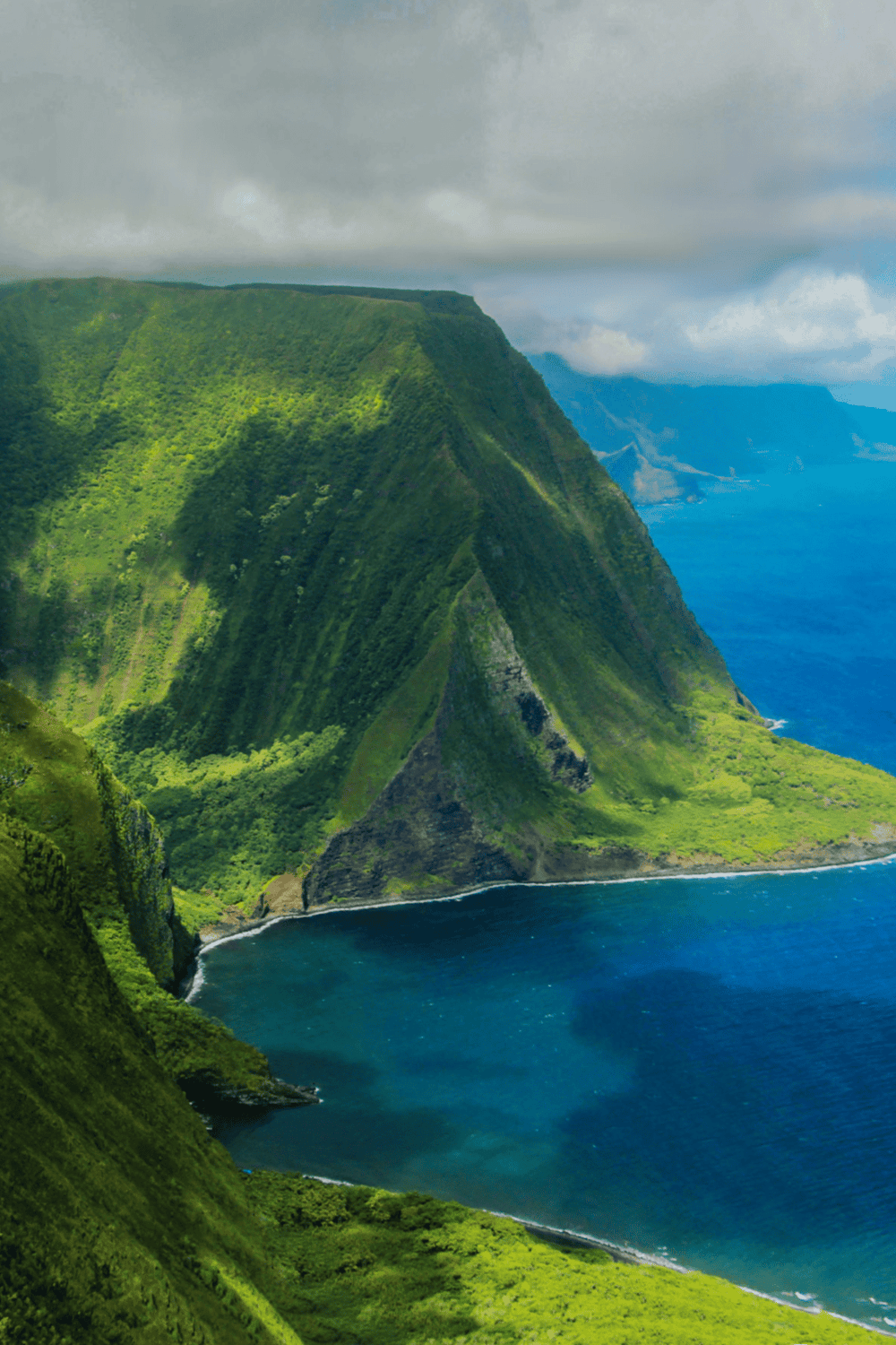Lush green mountains overlooking the blue ocean, showcasing scenic Hawaii coastal landscapes.