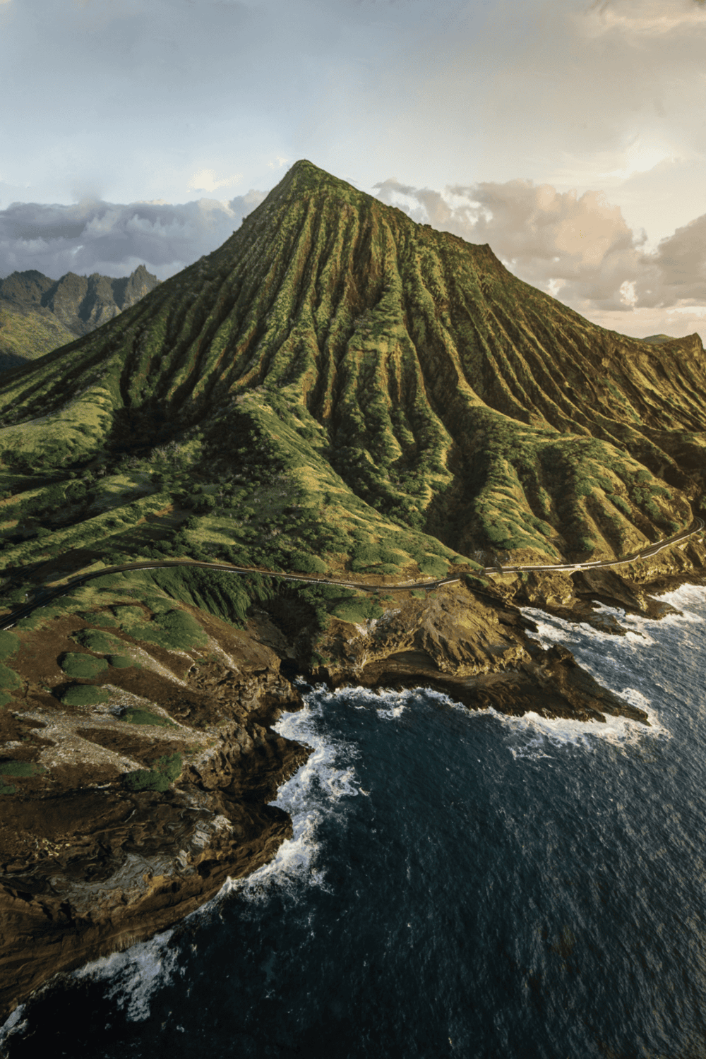 Lush green mountain with steep ridges and ocean coastline, scenic Hawaiian landscape, Aerial view of Na Pali Coast.
