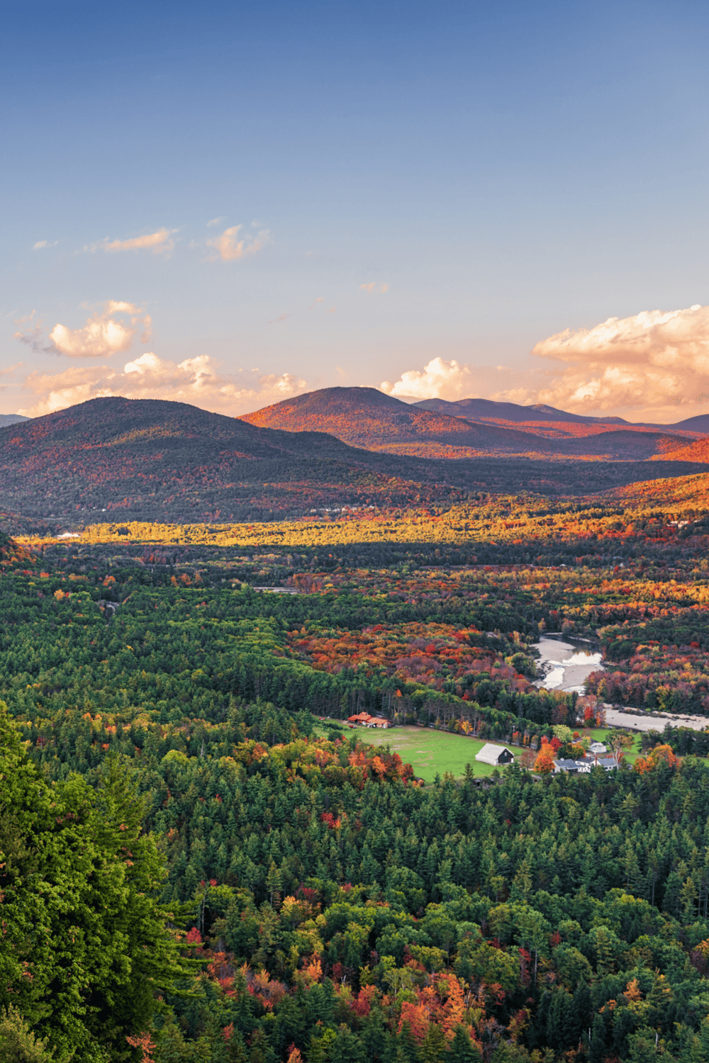 Rolling mountain landscape with autumn foliage and scenic river view.