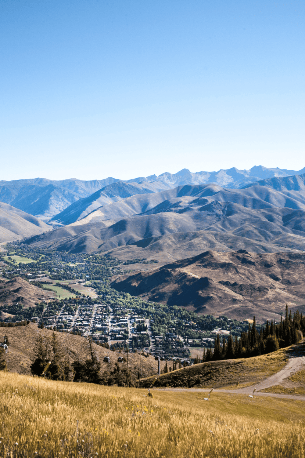 Scenic mountain landscape with a small town and lush greenery, ideal for travel and outdoor adventure visuals.