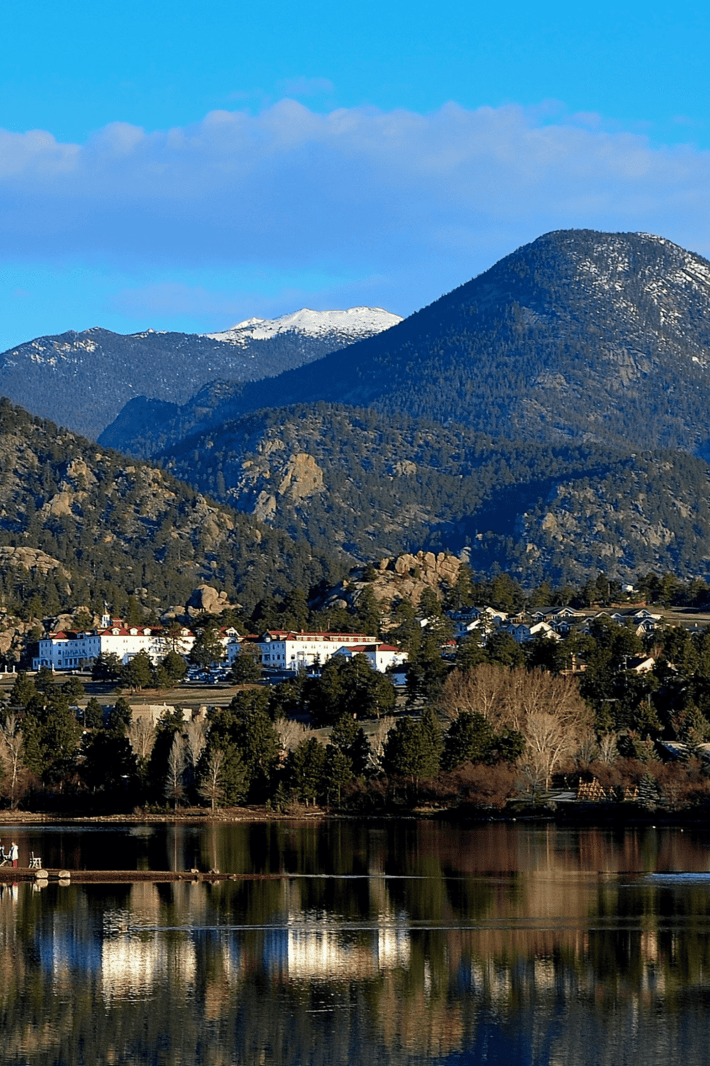 Serene mountain landscape with lake, forest, and city views, ideal for outdoor adventure and scenic travel.