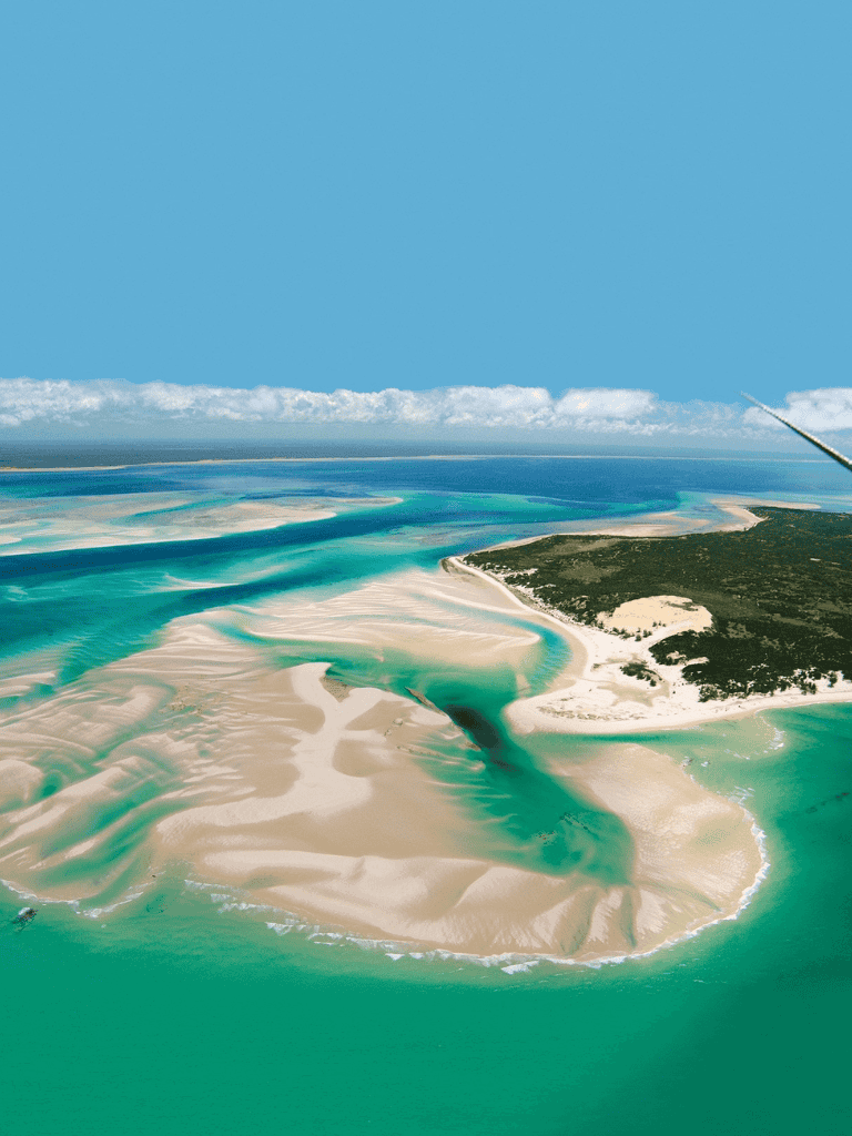 Vast coastal sand dunes and turquoise waters from an aerial view in a tropical destination.