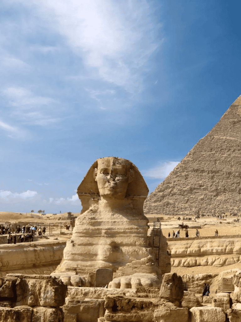 Majestic Sphinx of Giza with Great Pyramid in Egypt under blue sky.