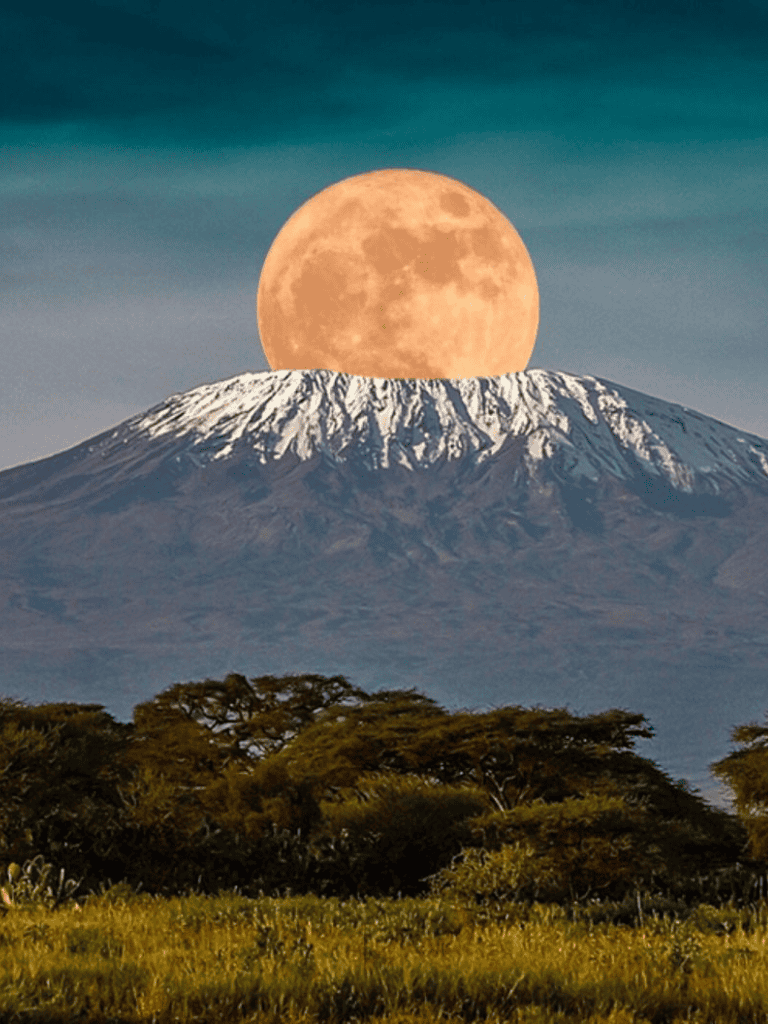Full moon over Mount Kilimanjaro with scenic landscape, guiding adventure, and travel insights.