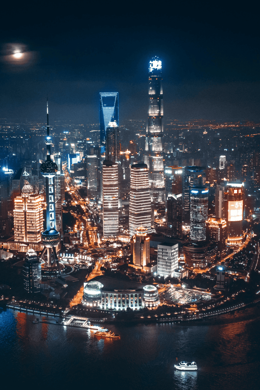 Bright night skyline of Shanghai with illuminated skyscrapers and river views.