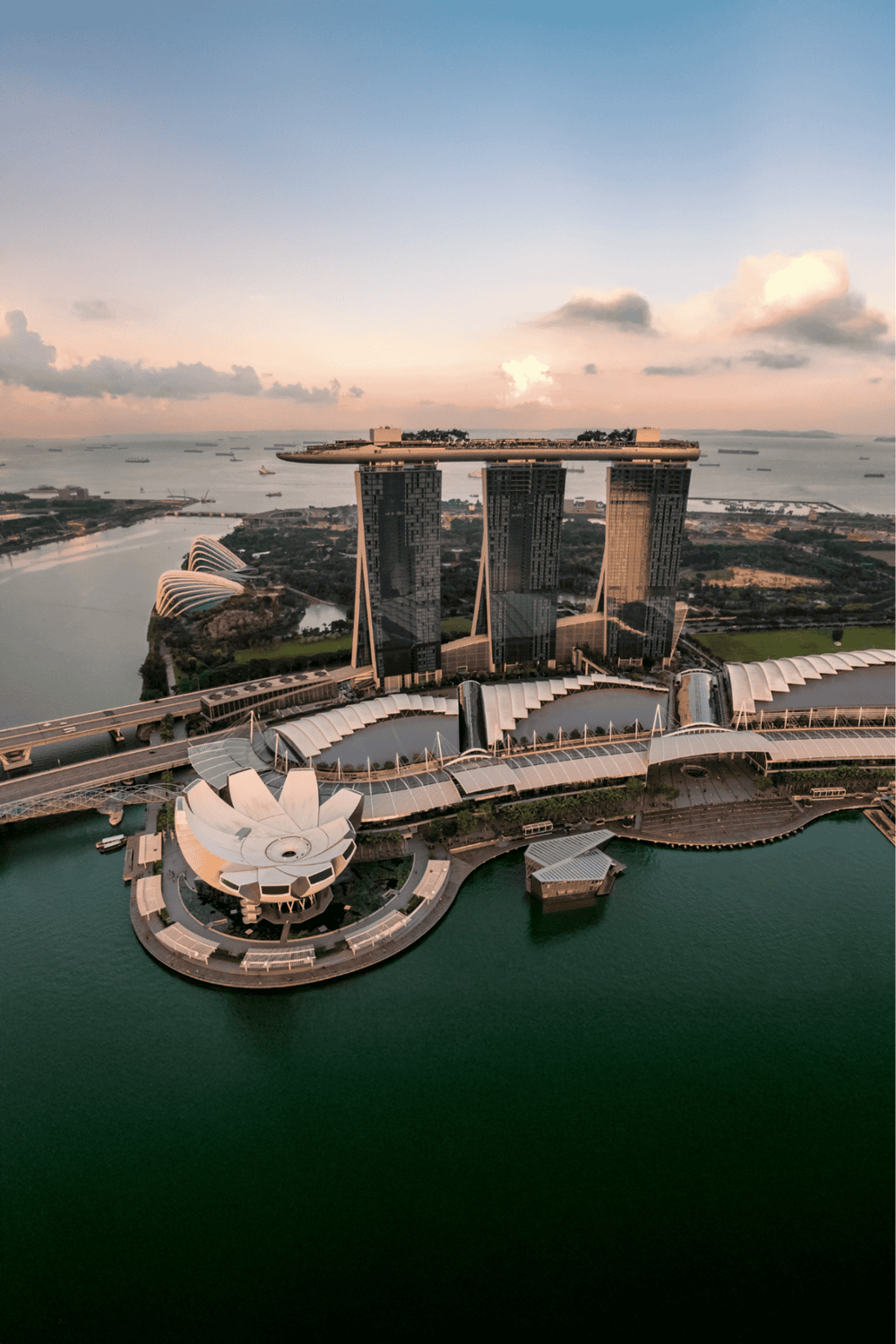 Modern Singapore skyline with Marina Bay Sands and ArtScience Museum at sunset.