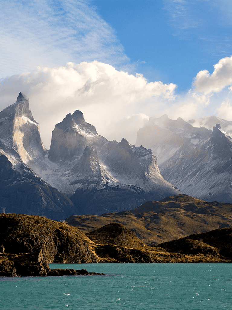 Majestic mountain landscape with snow-capped peaks and vibrant waters, perfect for adventure and nature travel.