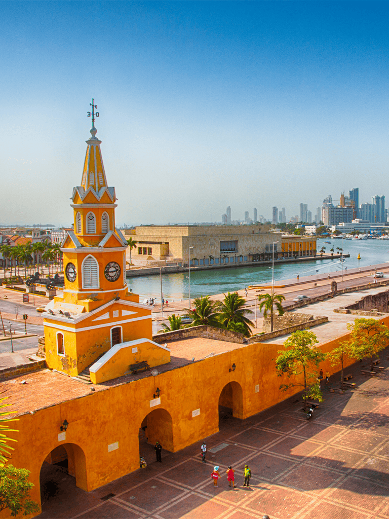 Colorful historic church in Miami's waterfront district, vibrant city skyline in background.