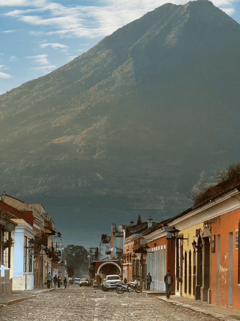 Mexico City street with colonial buildings and a mountain in the background, showcasing cultural heritage and scenic landscapes.