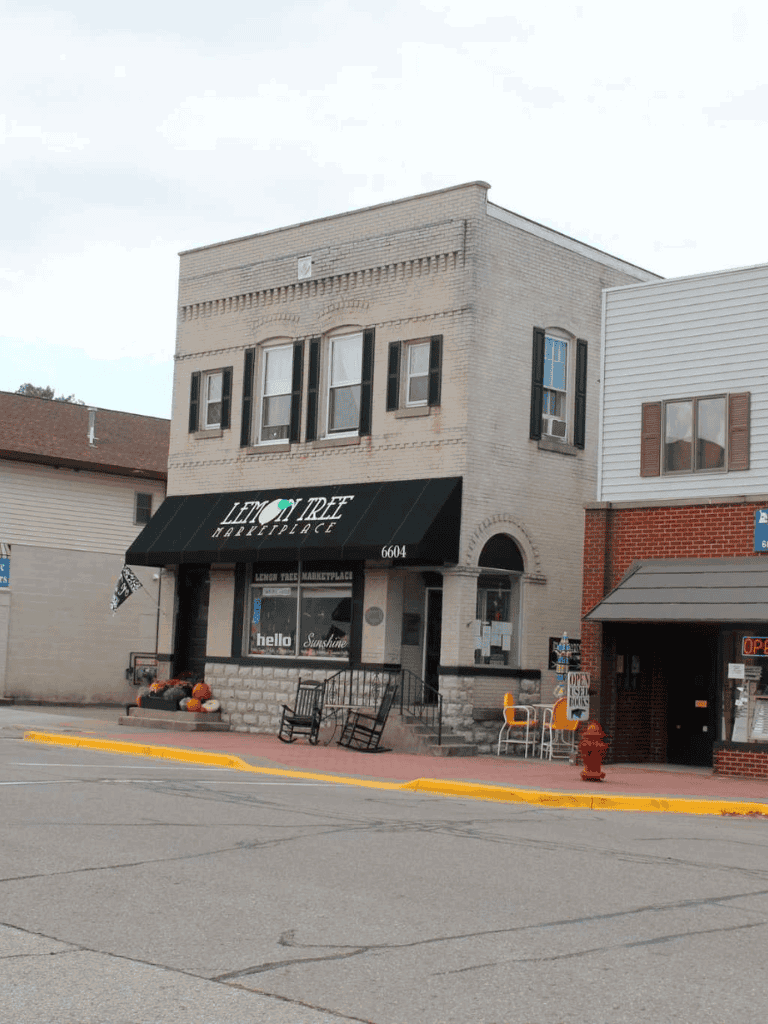 Cozy storefront of Lemon Tree Marketplace with outdoor seating and fall decorations.